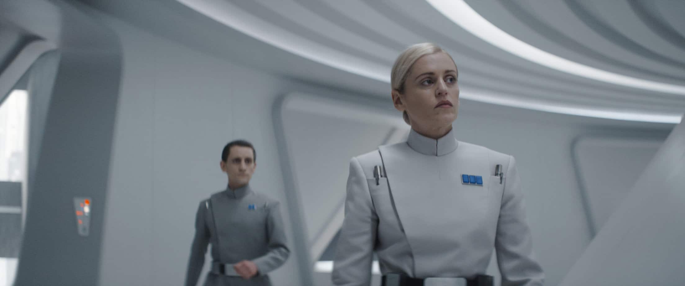 Is Andor kid friendly? parents guide to disney plus star wars show. woman in white uniform in a hallway with a man in a grey uniform behind her.