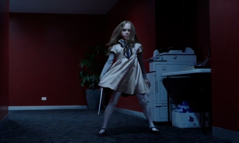 age rating of M3GAN parents guide. Megan movie 2023. One doll standing holding a knife.