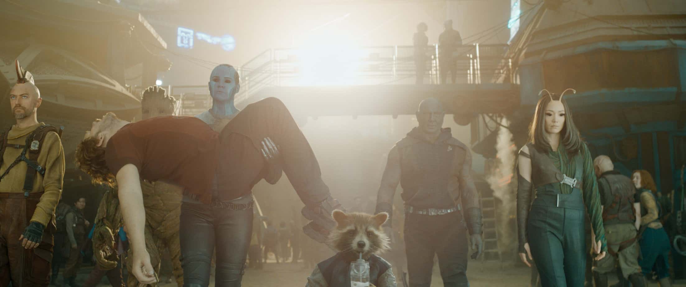 Age rating of GUARDIANS OF THE GALAXY VOL. 3 parents guide. All the guardians walking together with Star Lord in Drax's arms.