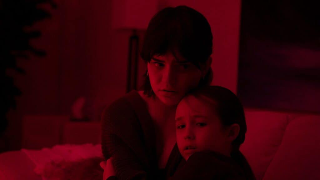 age rating of the boogeyman parents guide. two girls hugging each other sitting in a room bathed in red light.