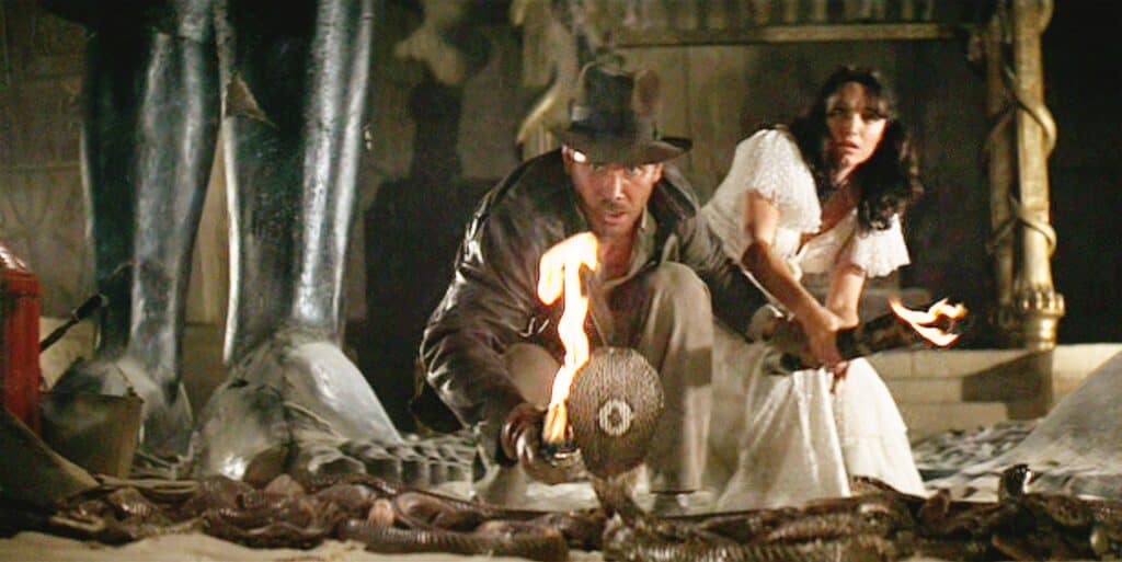 Indiana Jones with a fire torch and a snake. age rating of raiders of the lost ark. 