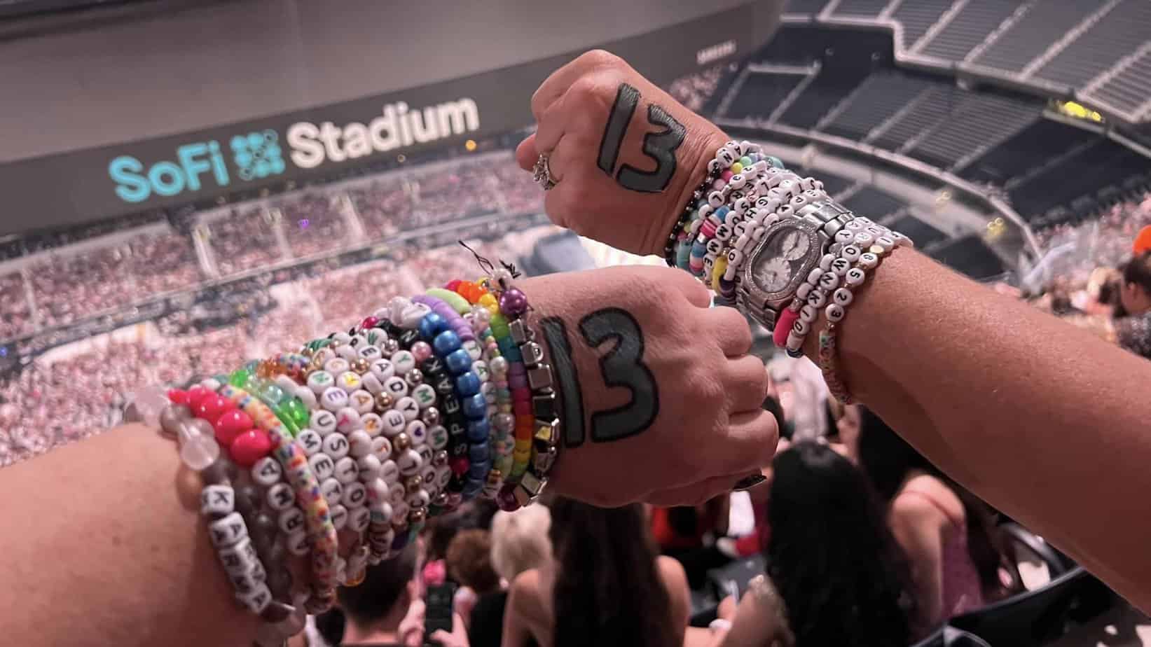 two hands with 13s on them and friendship bracelets at the Taylor Swift SoFi Stadium tour. 